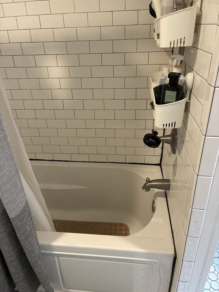 Spotless tiled bathtub and shower area